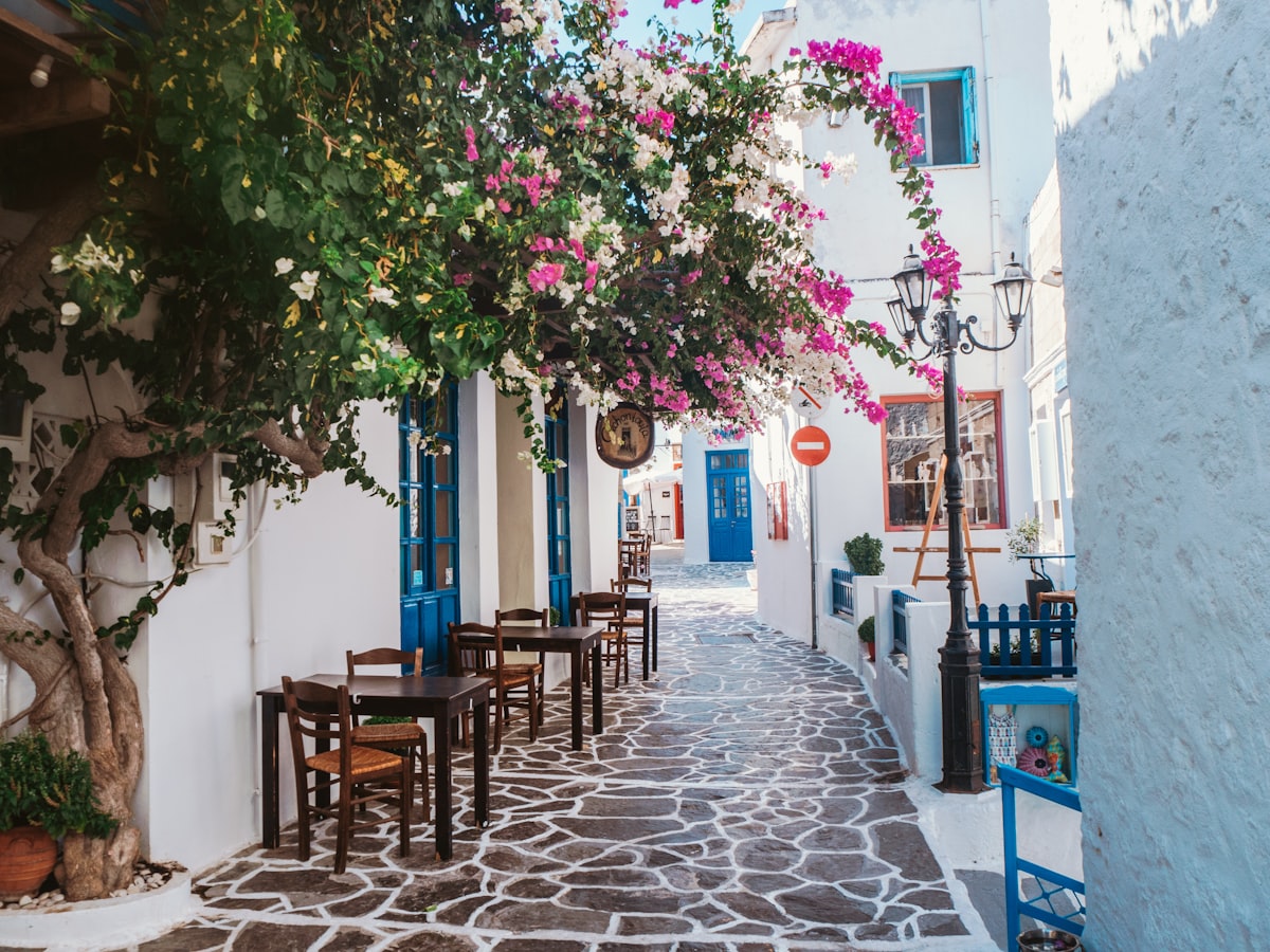 Callejuela blanca con buganvillas en una isla griega